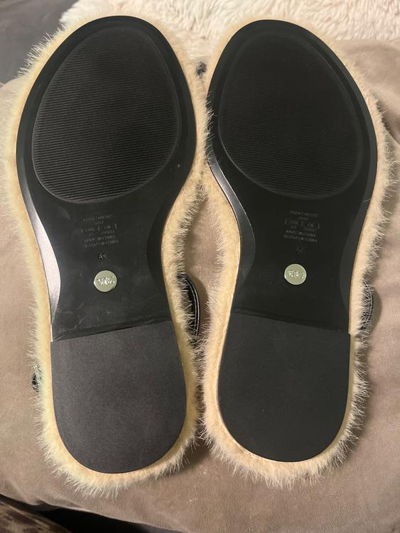 Shoe soles with a beige fur trim on a soft surface. Visible text: "Made in China" and "36".