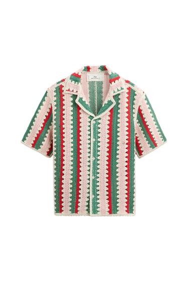 Crochet shirt with vertical stripes in green, red, and white. Short sleeves and open collar. Visible tag on the inside of the collar.