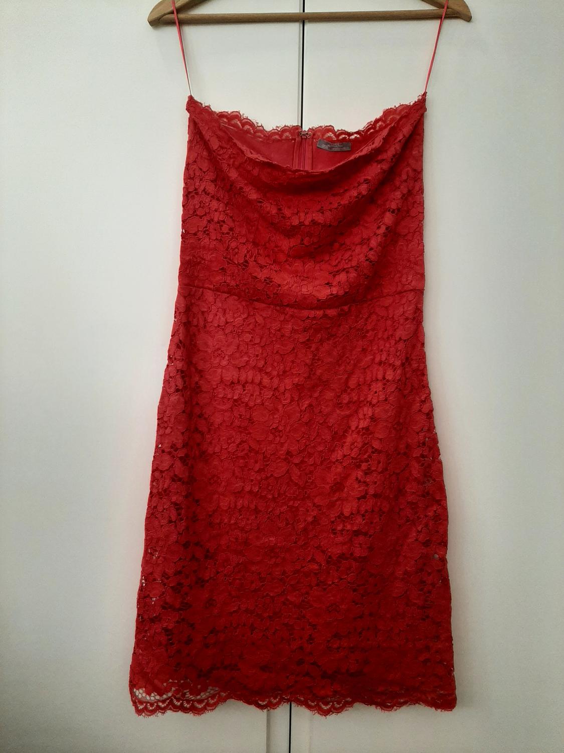 Front view of red lace dress with thin straps and rounded neckline.