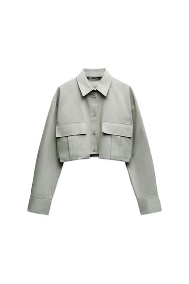 Light grey cropped jacket with large chest pockets and button fastening, on a white background.