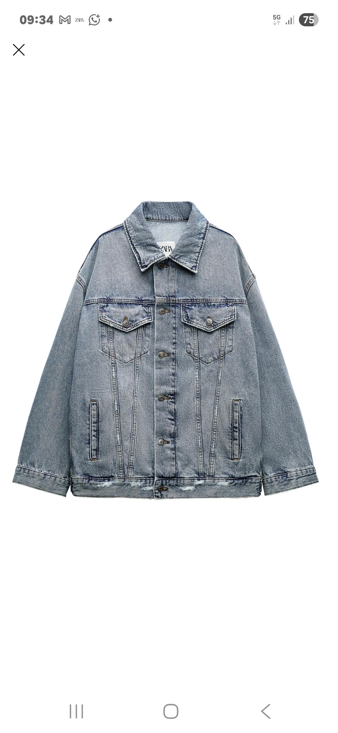 Light blue denim jacket with front buttons and flap pockets. White background. Visible label on the collar.