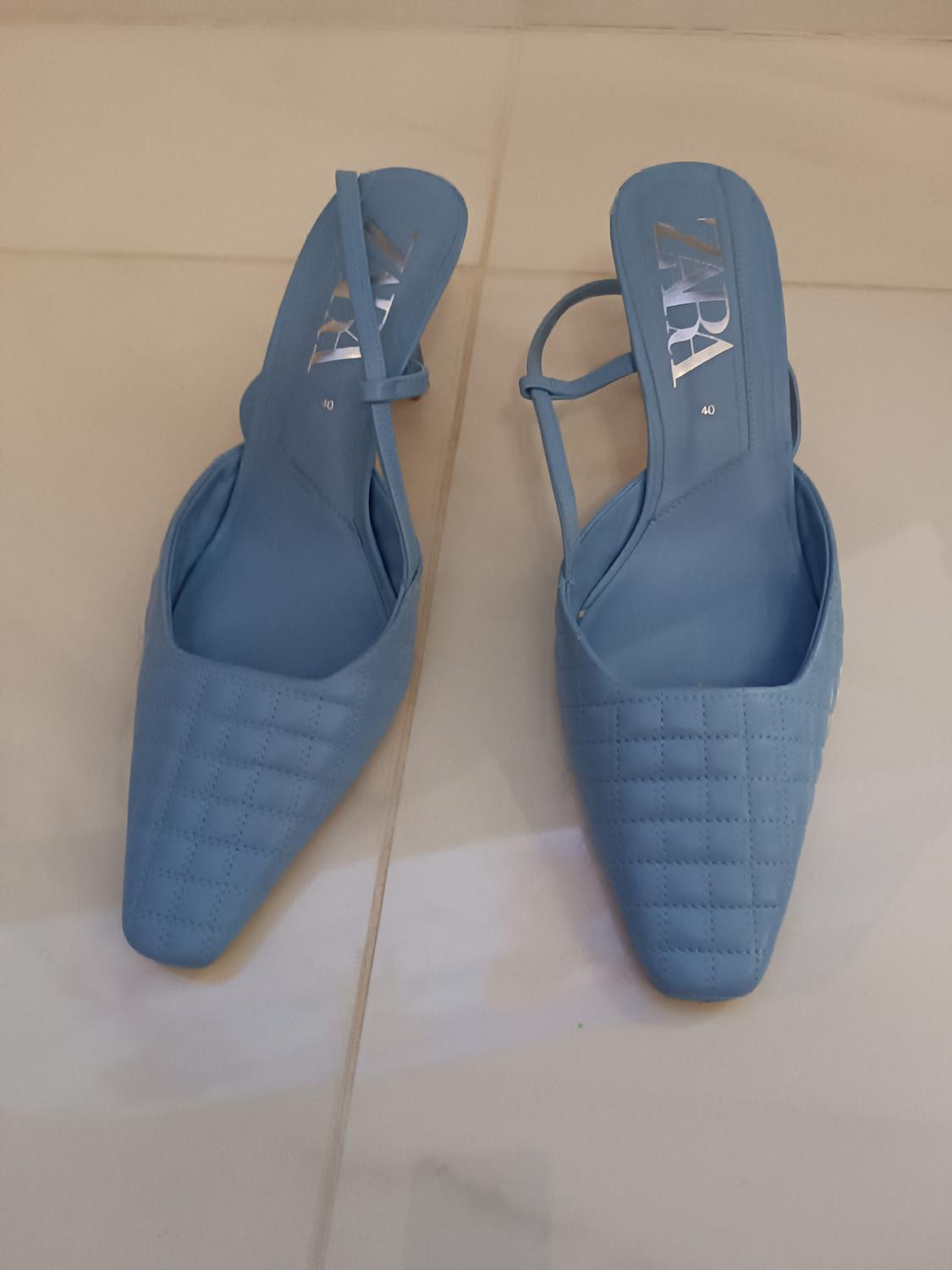 Blue square-toed shoes with straps, on a light floor. The insole shows the text "ZARA" in silver letters.