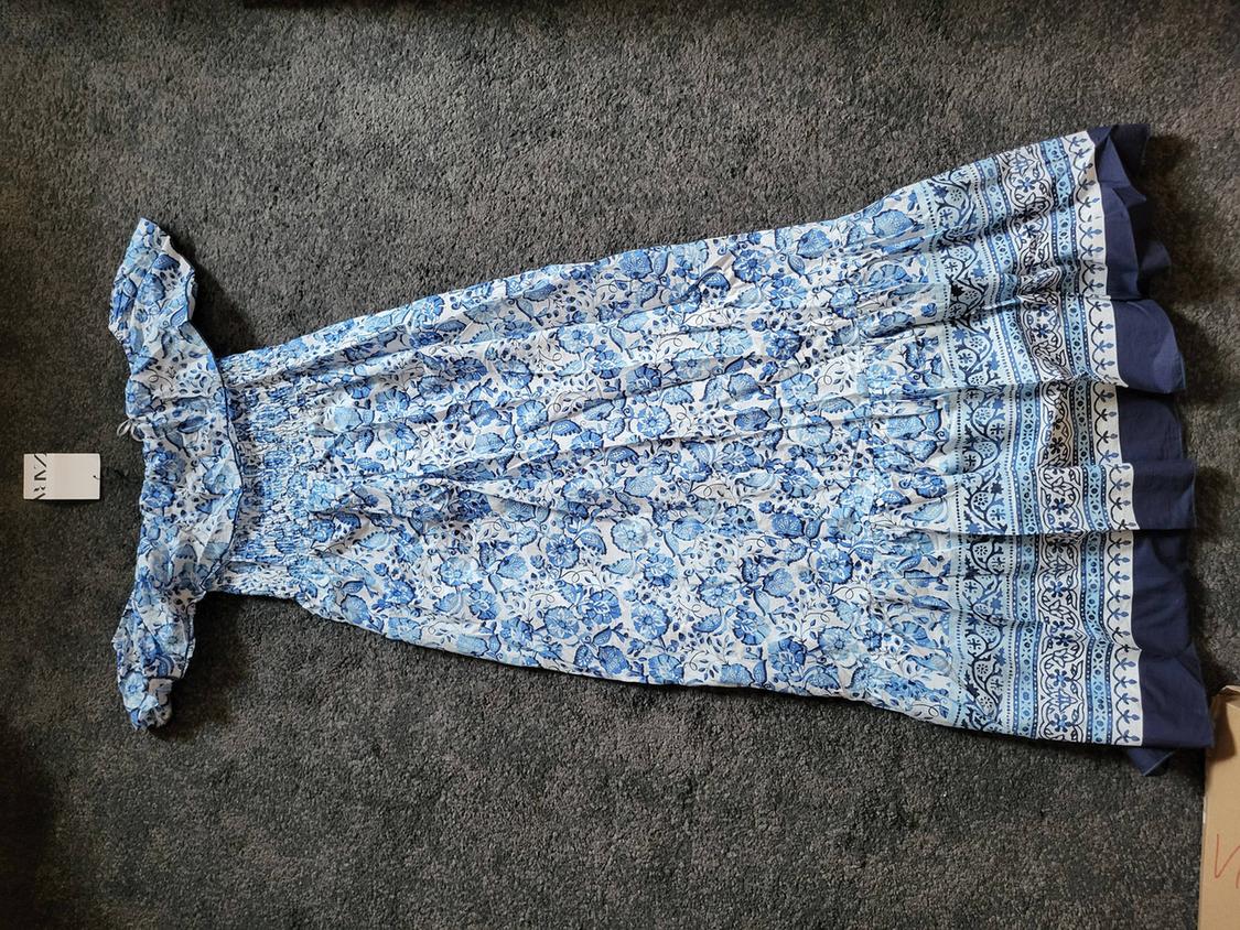 Long blue dress with white and blue floral print, on a grey rug. Visible label with text "ZARA".