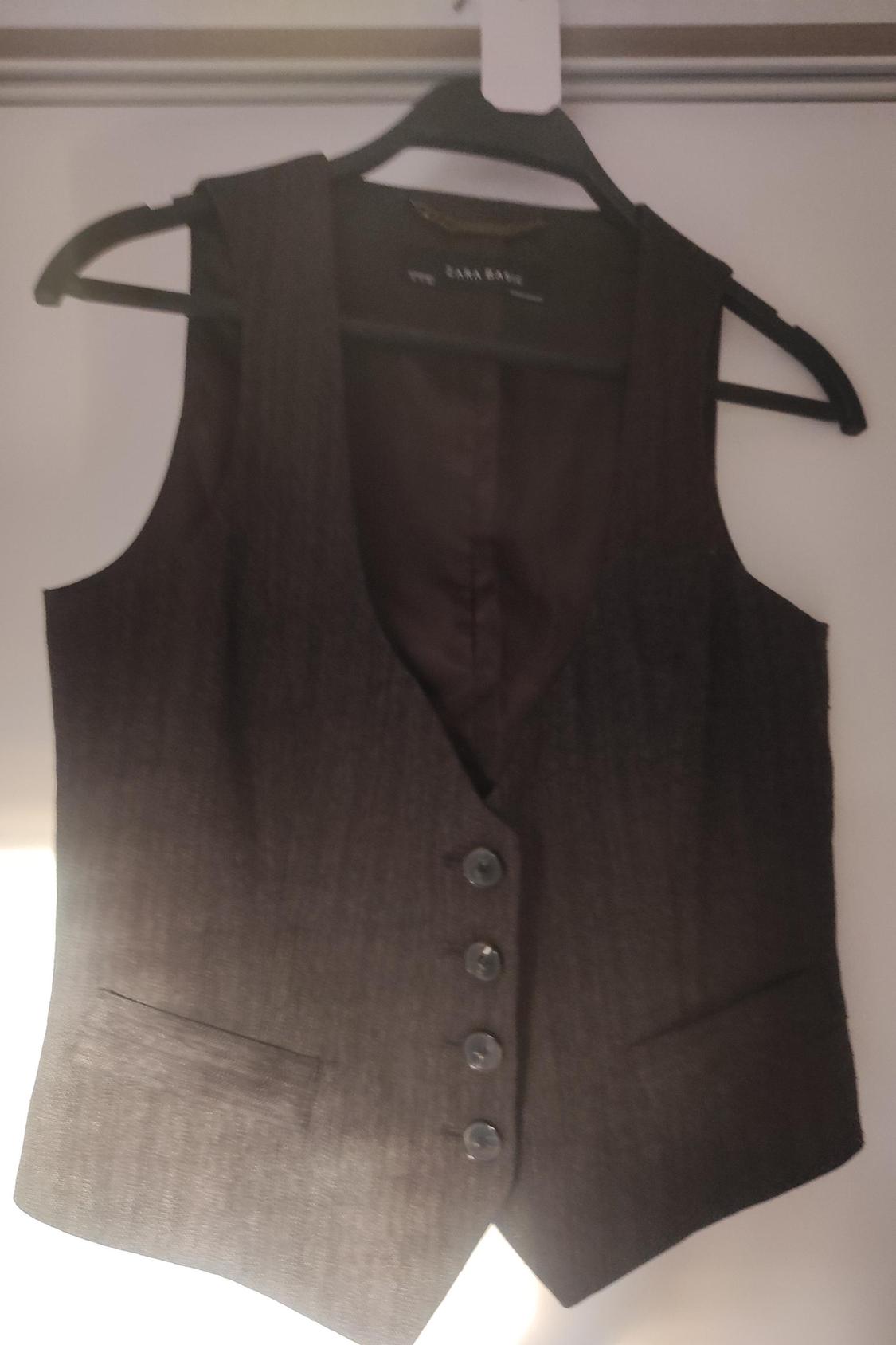 Front view of brown waistcoat with buttons and side pockets.