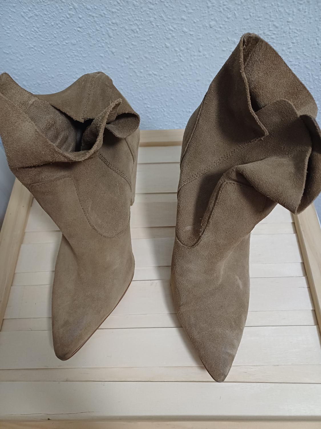Top view of brown high boots with pointed toe and pleats in the design.