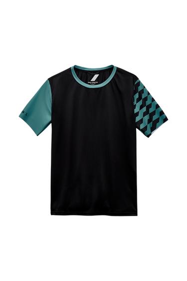 Front view of a black t-shirt with a round neck and green sleeves, one with a geometric print and '8 1' text.