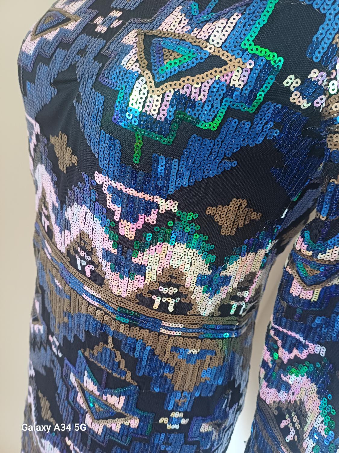 Dress with blue, green, and gold sequins in a geometric design. Text in image: "Galaxy A34 5G".