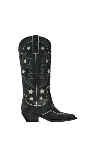 Side view of a black boot with white embroidered stars and designs.