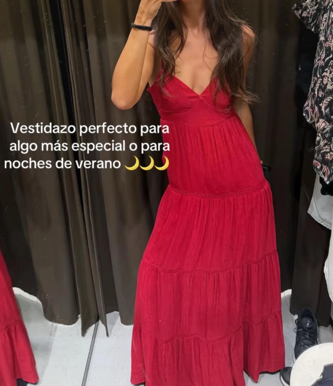 Woman in a changing room wearing a long red dress. Text: Stunning dress for something a little more special or for summer evenings.