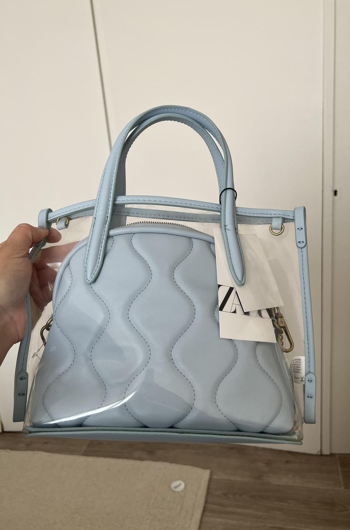 Light blue bag with a wavy design and handles, front visible.