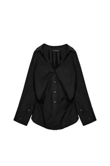Front view of black shirt with classic collar, central button placket and chest pocket. Long sleeves with buttoned cuffs.