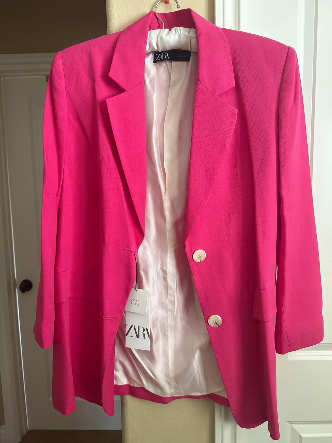 Fuchsia jacket hanging on a hanger, with white lining and large buttons. Visible tag with the text "ZARA JOIN LIFE".