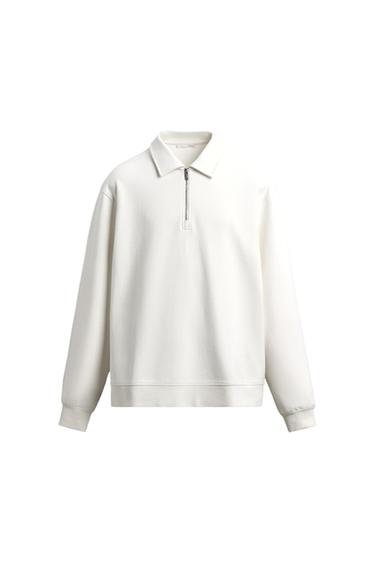 White sweatshirt with a front zip and polo neck, white background.