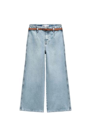 Light blue wide-leg denim trousers with front pleats and a thin brown belt, on a white background.