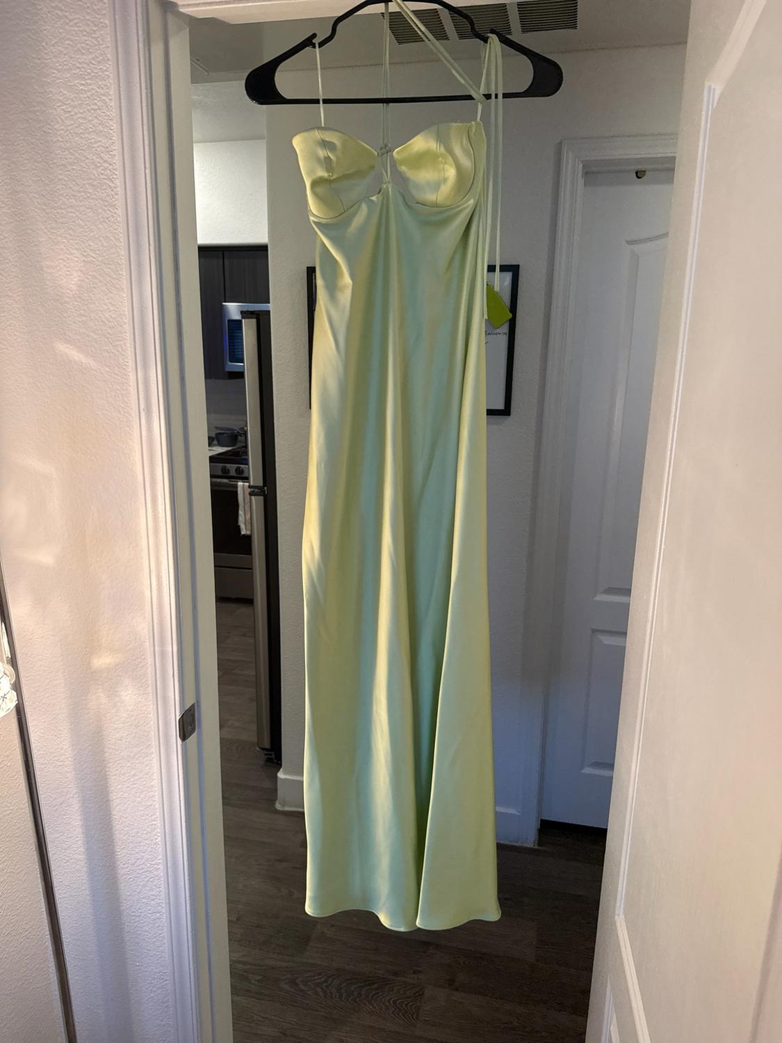 Light green satin maxi dress with a sweetheart neckline and thin straps, hanging on a black hanger in a white door frame.