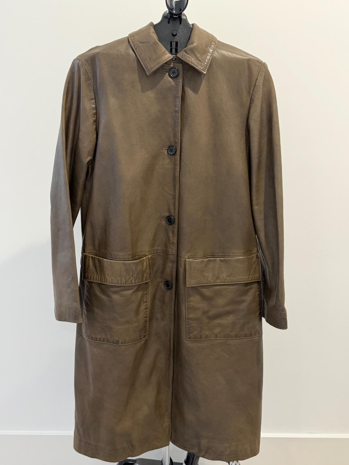 Long brown leather coat with front buttons, classic collar, and two flap patch pockets, hanging against a white background.