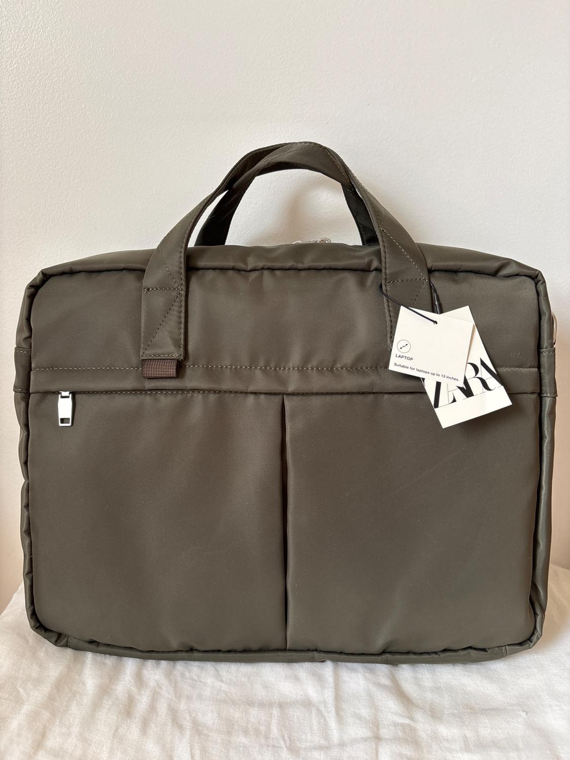 Khaki quilted tote bag with two handles and tag that reads "LAPTOP Suitable for laptops up to 15 inches".