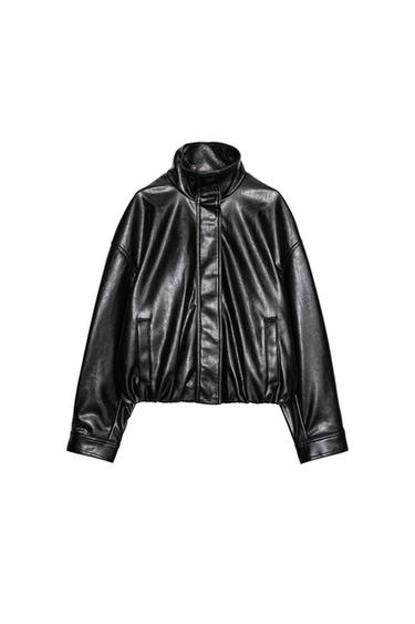 Front view of a short black jacket with a stand-up collar, long sleeves and side pockets. Front fastening with zip and buttons.