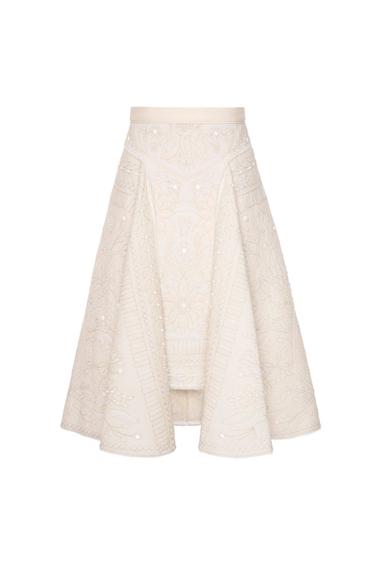 Front view of beige skirt with floral embroidery and decorative pearls.