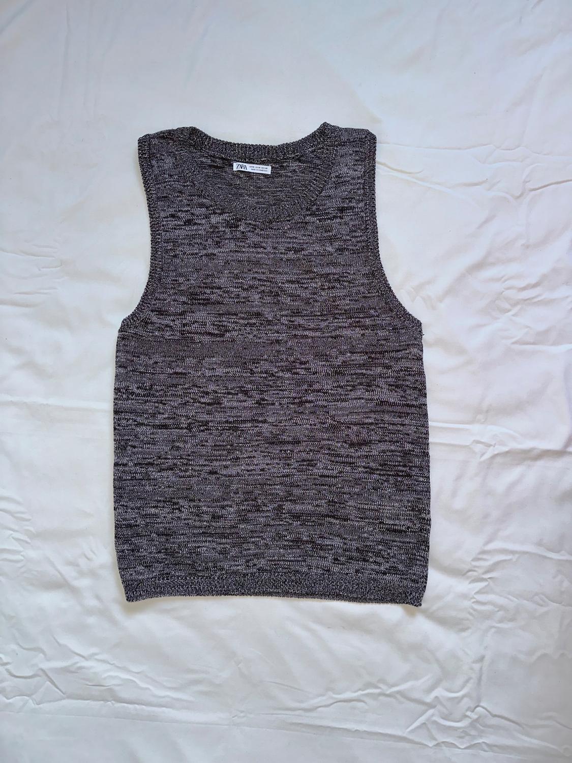 Sleeveless marl grey vest on a wrinkled white background. Label visible on the neck with text "ZARA".