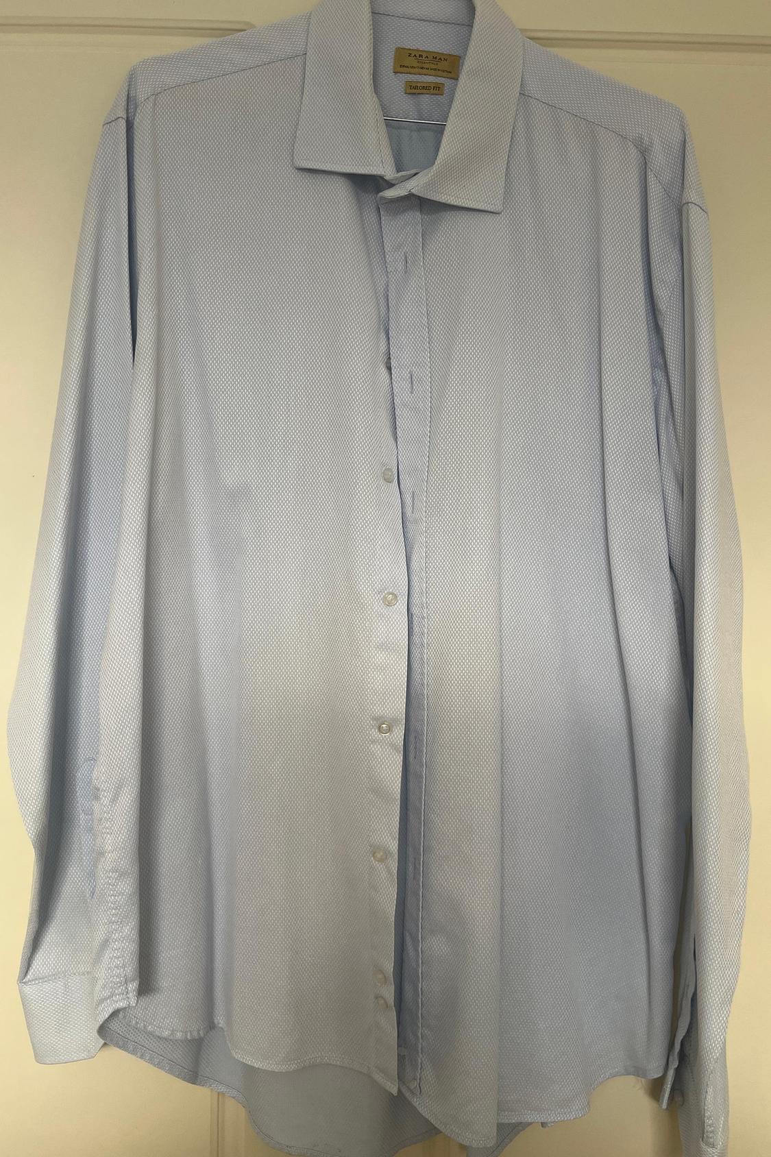 Front view of a light blue button-up shirt with a wide collar.