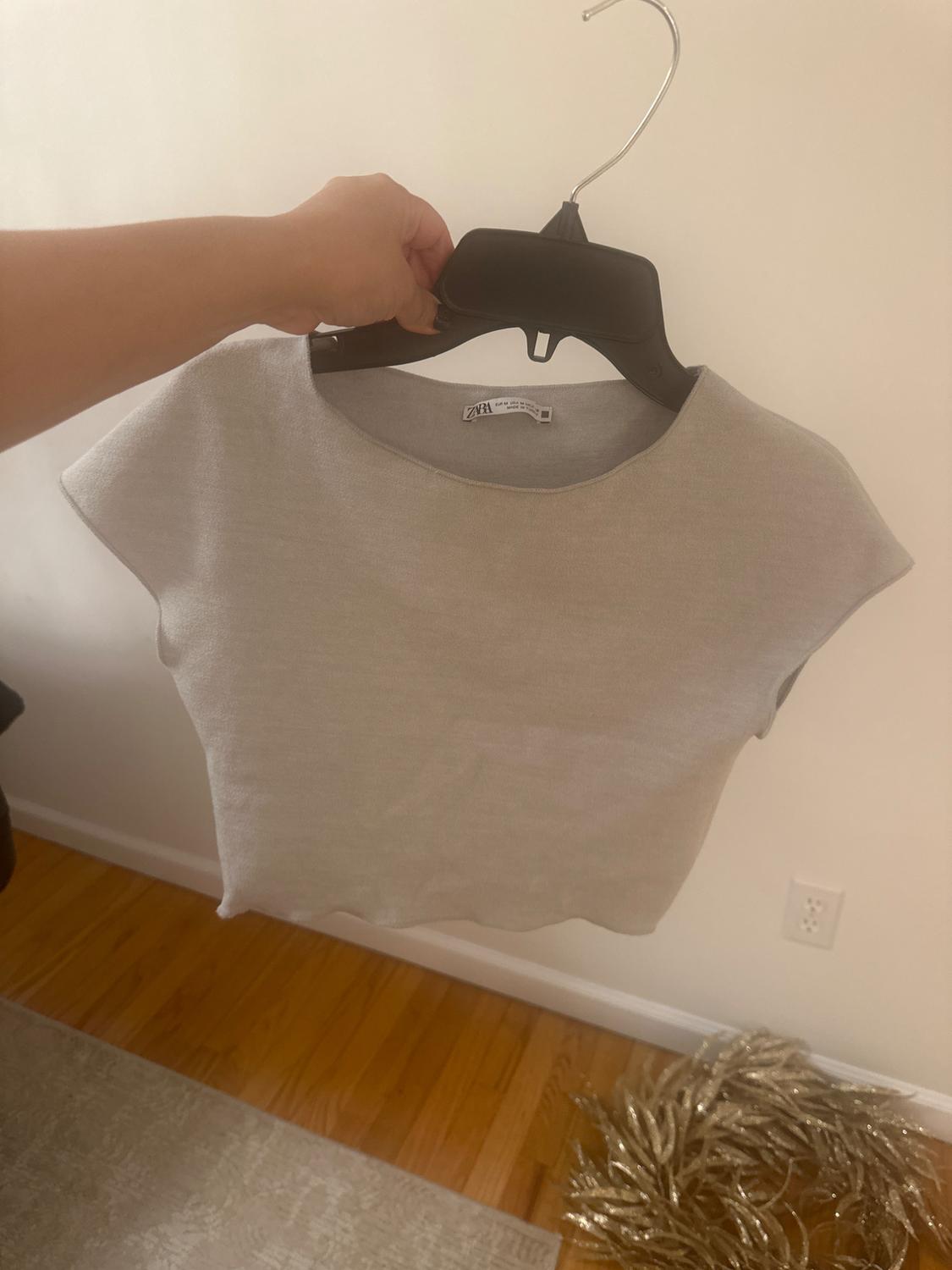 Front view of a grey t-shirt on a hanger with a crew neck and short sleeves.