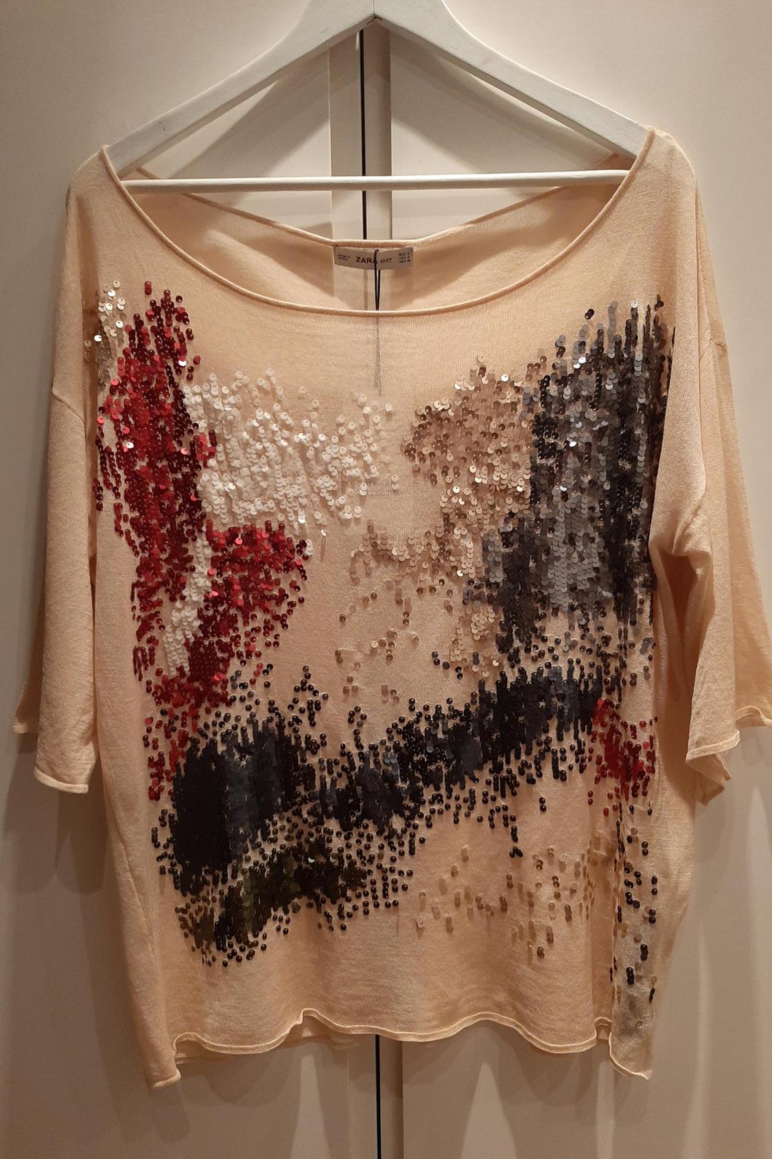 Front view of a beige t-shirt with abstract multicoloured sequins.