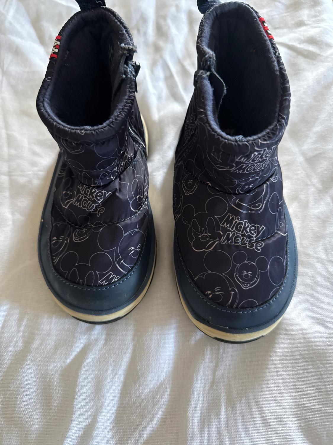 Black children's boots with Mickey Mouse drawings and his name in white. White background.