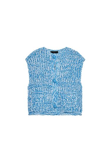 Front view of a knitted blue waistcoat with large buttons and front pockets.