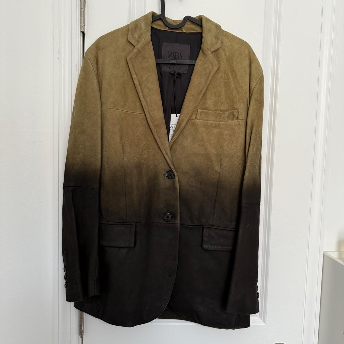 Jacket hanging on a hanger, with a light to dark brown gradient design. Label visible on the inside.