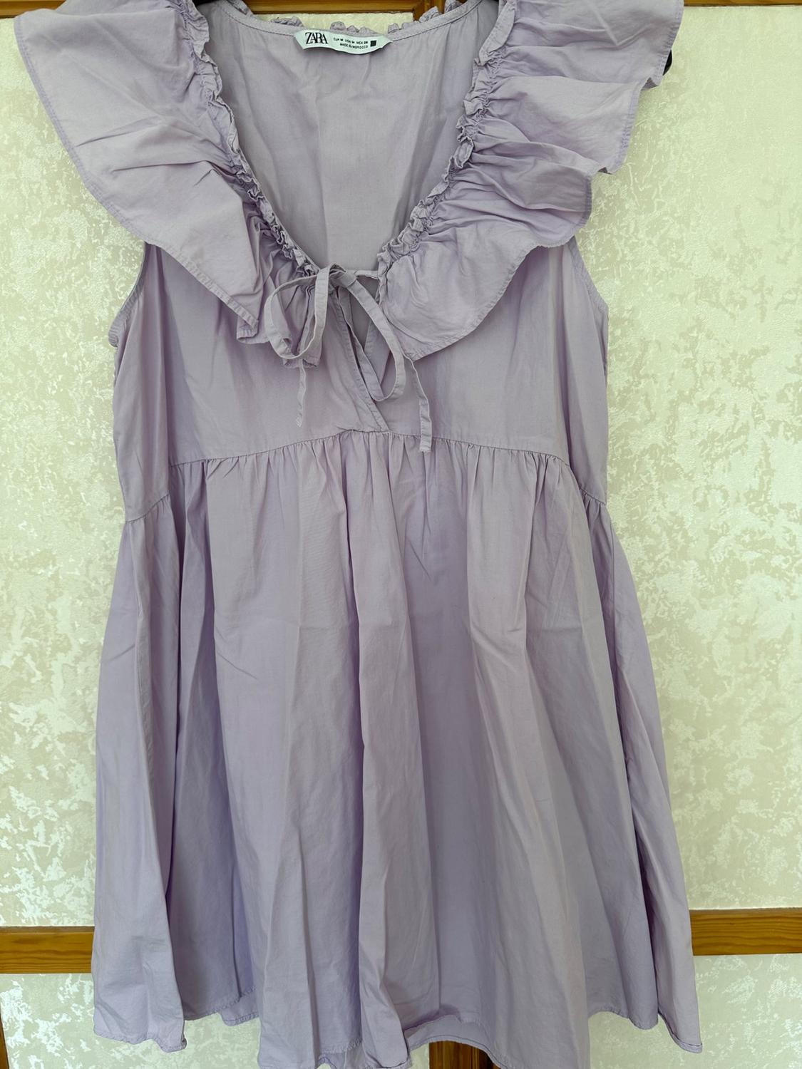 Front view of lilac dress with frill on the collar and bow.