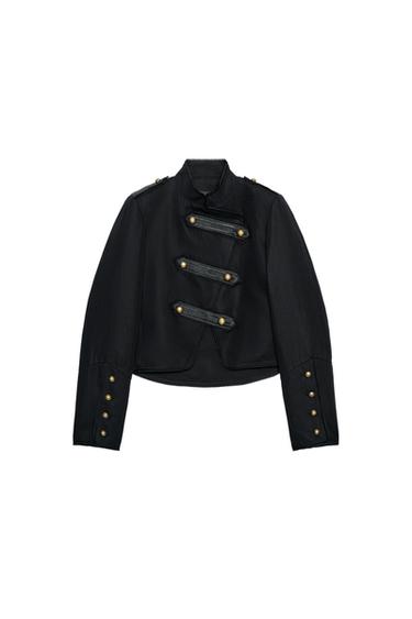 Front view of a short black blazer with a funnel neck, long sleeves, decorative gold buttons, and an asymmetrical fastening.