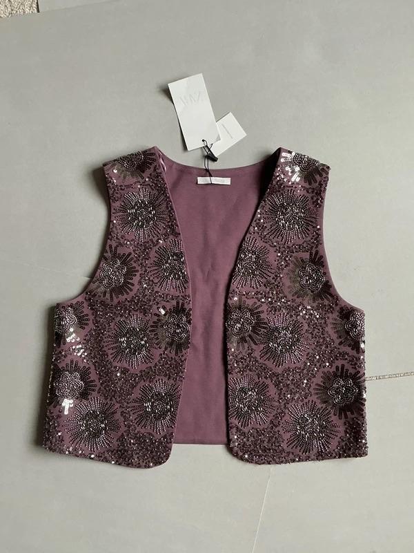 Purple sleeveless waistcoat with sequins and a floral design on a grey background. Tags hanging from the neck.