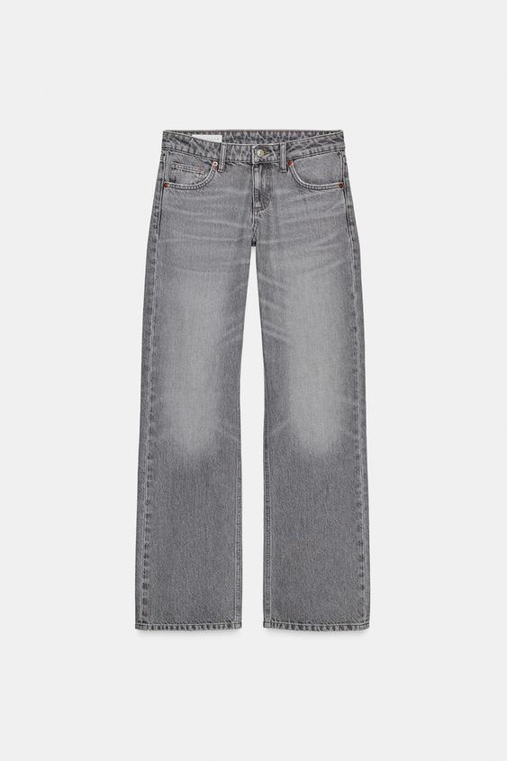 Přední pohled na šedé džíny s nízkým pasem, širokými nohavicemi a pěti kapsami. Přední zapínání na zip a kovový knoflík.