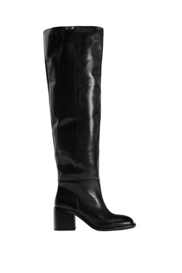 Side view of a black knee-high boot with a low heel and round toe.