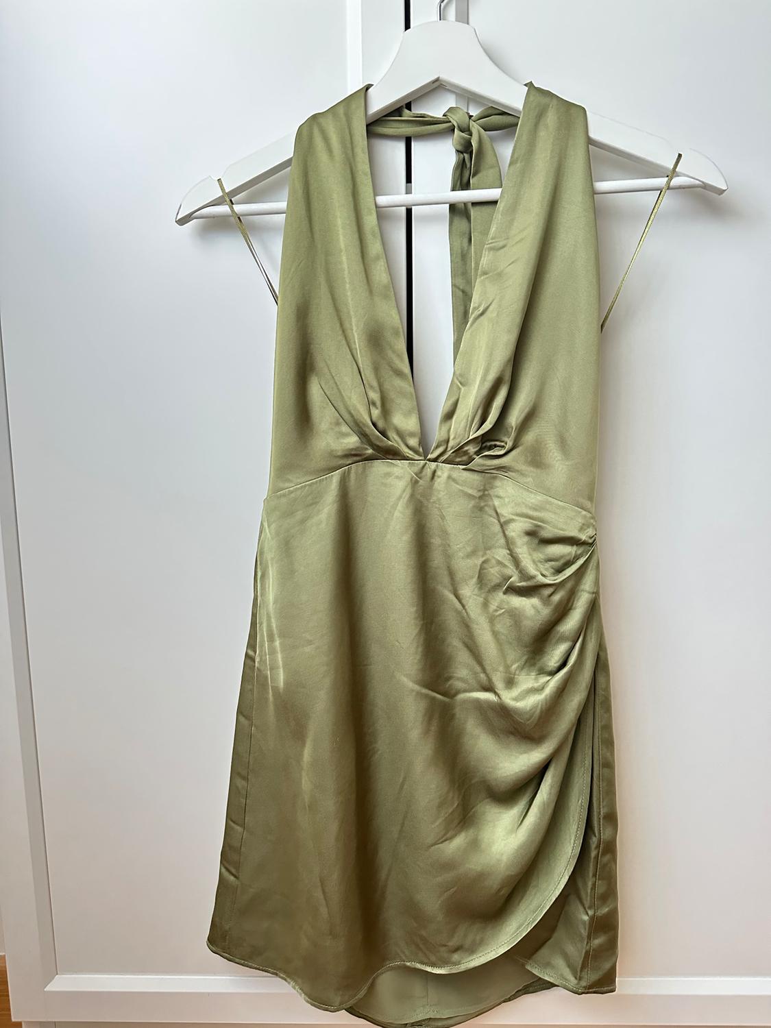 Olive green satin dress with a deep neckline and thin straps, hanging on a white hanger against a white background.