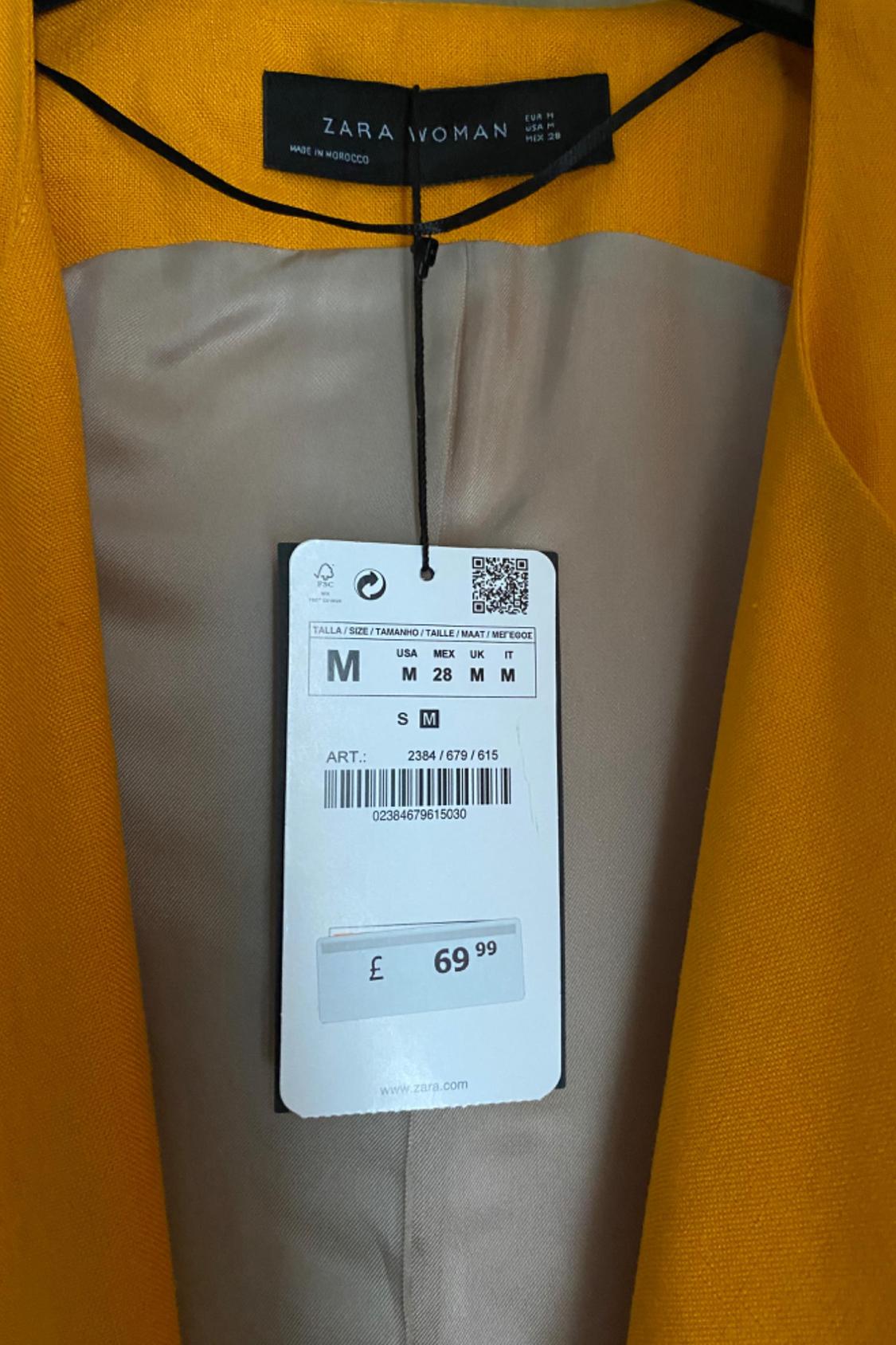 Label detail on yellow jacket with price £69.99 and size M.