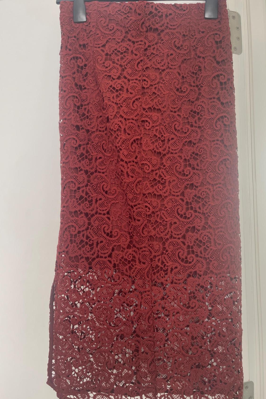 Front view of red lace skirt with intricate floral design.