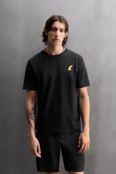 טי שירט עם הדפס גרפי של גלישה - שחור של Zara