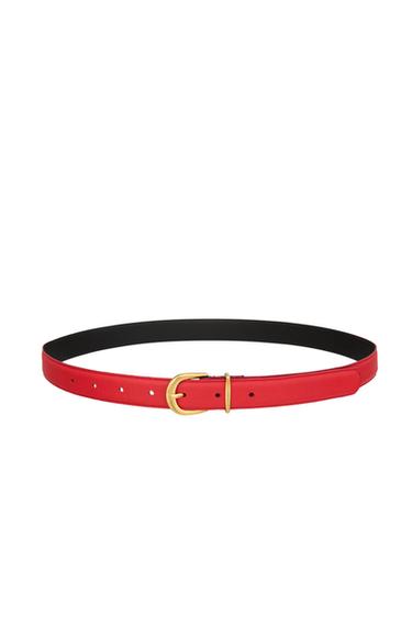 Red belt with a gold buckle on a white background. Minimalist and elegant design, ideal for complementing any outfit.