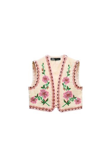 Front view of a beige waistcoat with pink and green floral embroidery, decorative trim on the edges.