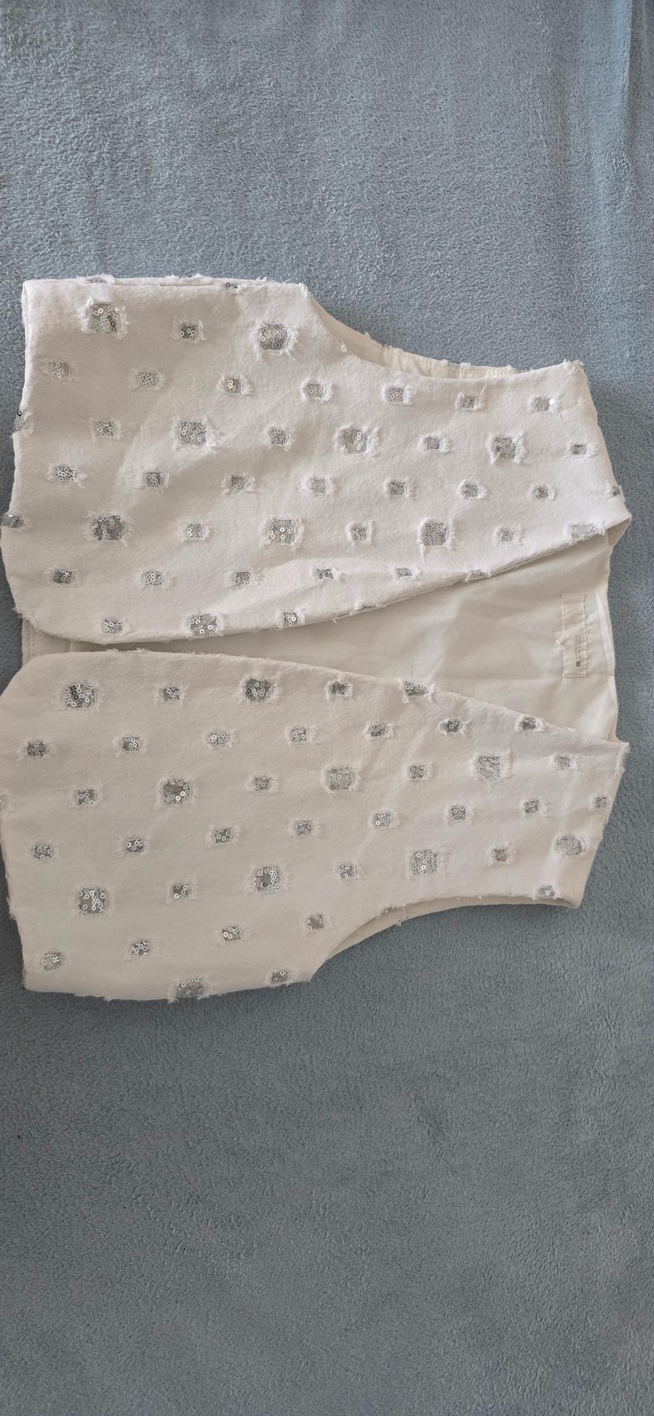 White fabric with silver sequins in a small check pattern on a grey background.