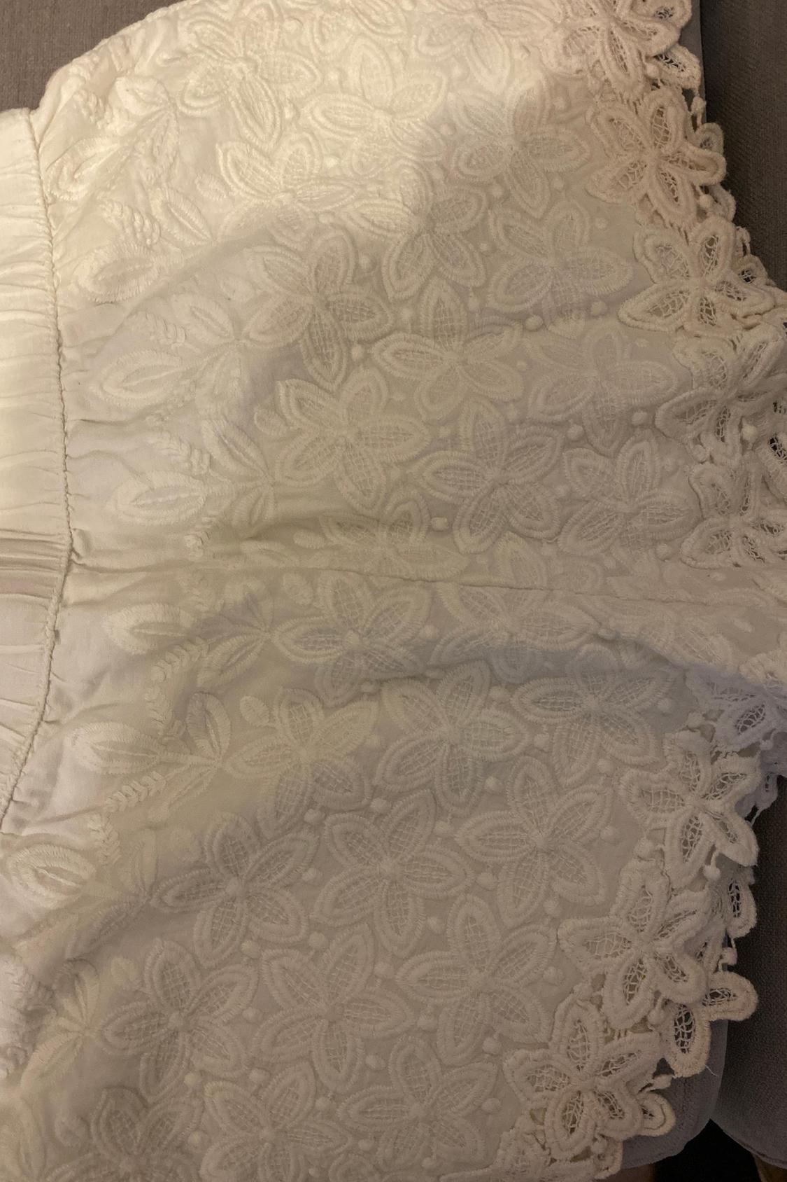 White floral lace detail on garment.
