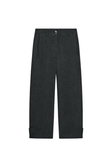 Front view of grey pinstripe trousers, high-waisted, front pockets, straight leg, adjustable hem with tab and buttons.