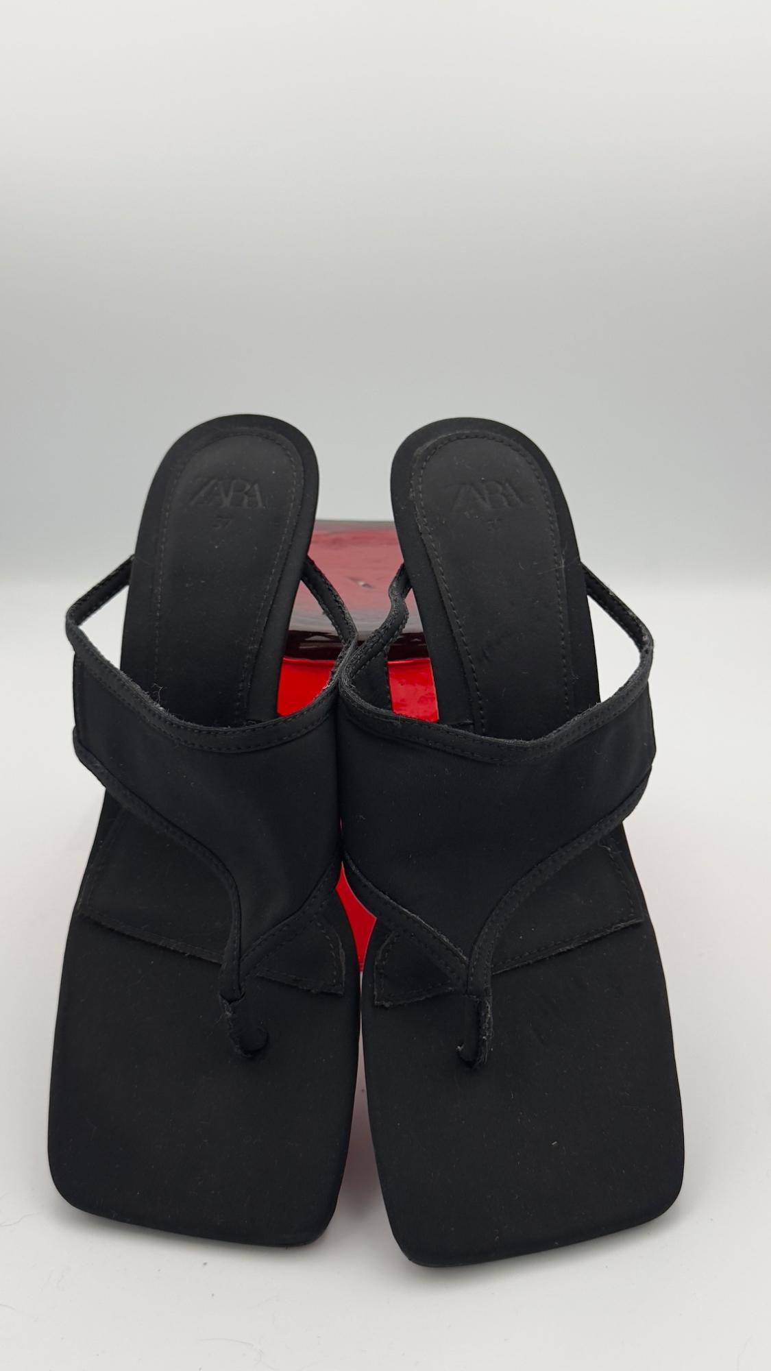 Black square heel sandals with wide straps, on a white background and a red block. Visible text: "ZARA".