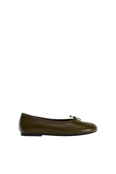 Olive green ballet flat with decorative bow on the upper, minimalist white background.