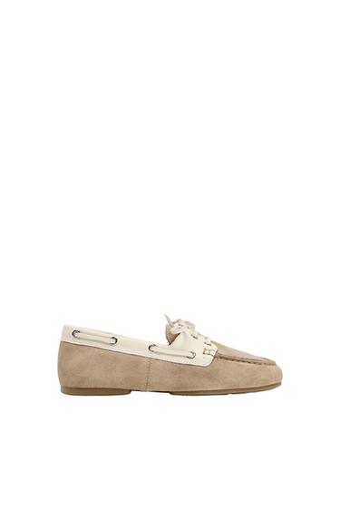 Beige suede deck shoe with a white upper and laces, shown in profile against a white background.