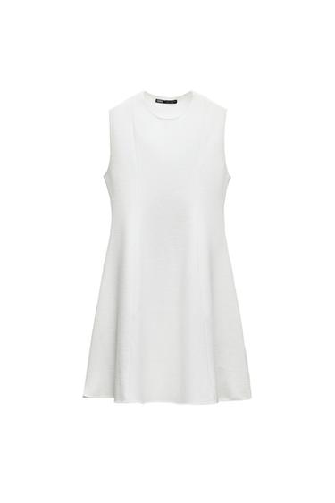 Front view of a sleeveless white dress with a round neckline.