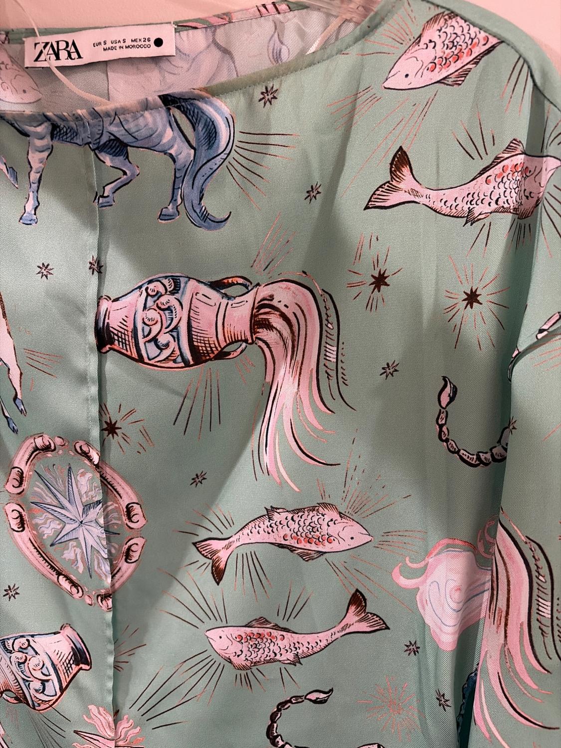 Mint green fabric with a print of fish, horses, and marine motifs in pink and blue tones. Visible label: "ZARA, MADE IN MOROCCO".