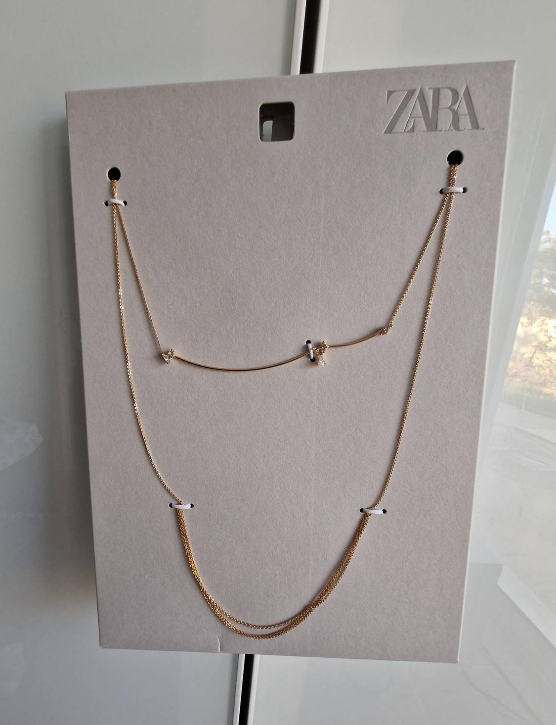 Gold-coloured double-chain necklace with sparkly details on a display card featuring the text ZARA.